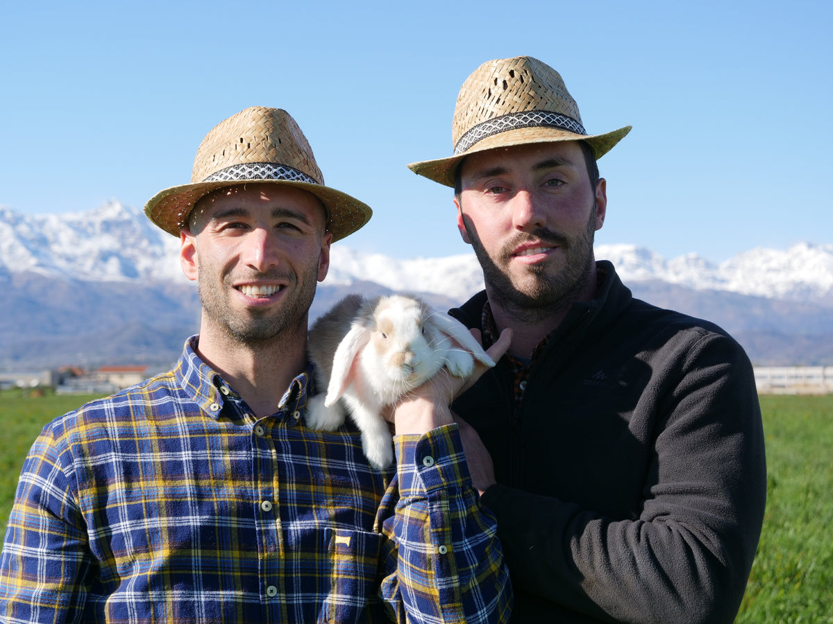 Davide e Alessandro di M2 Farm con un coniglio, davanti alle Alpi del Canavese